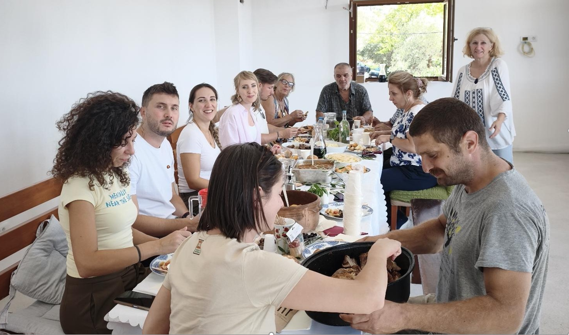 Visitors and Pelinovo residents share a long table filled with traditional dishes and local products after the outdoor activities.